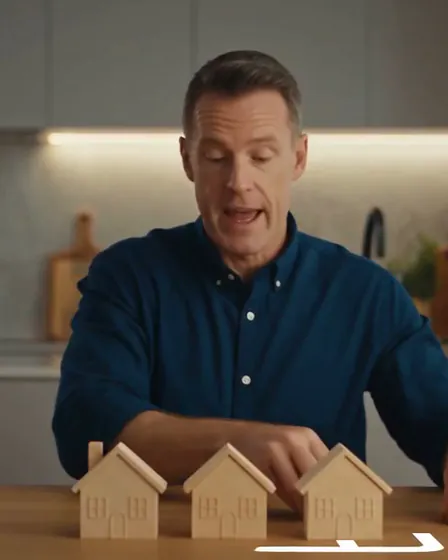 Marty Kerrison at the kitchen table, mid-explanation, with the three house blocks in front of him